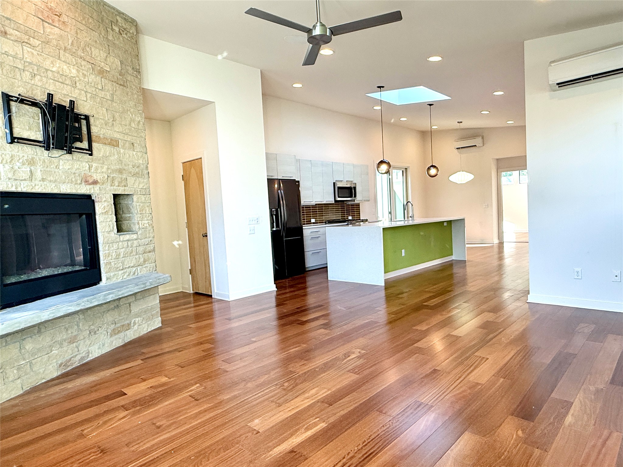 416 Starlight Village Loop Leander, TX 78641 - Photo 9 of 28 Unfurnished living room featuring ceiling fan, a fireplace, dark wood-style floors, and a high ceiling