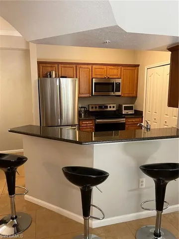 a kitchen with stainless steel appliances a stove refrigerator and a microwave