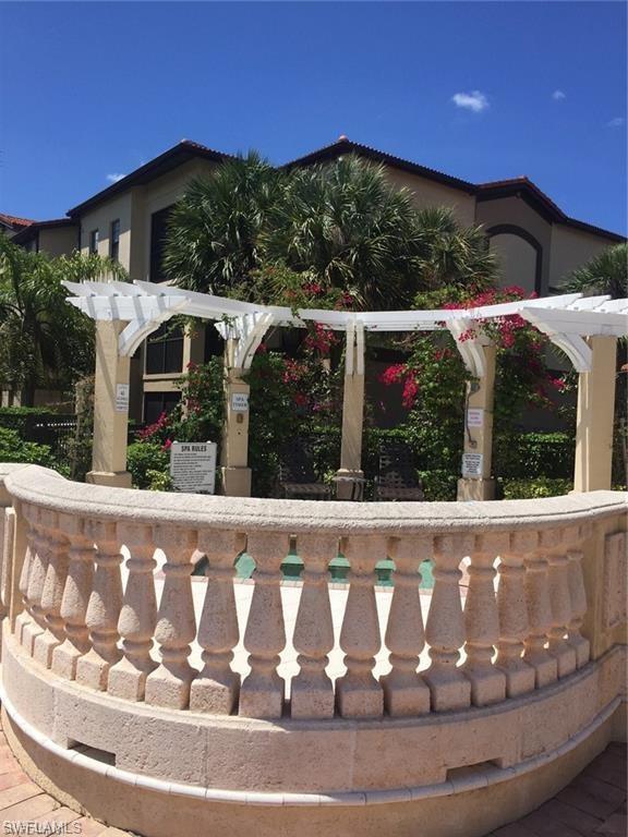 12975 Positano Circle, Unit 202 Naples, FL 34105 - Photo 10 of 14 a view of a small house with yard and outdoor seating