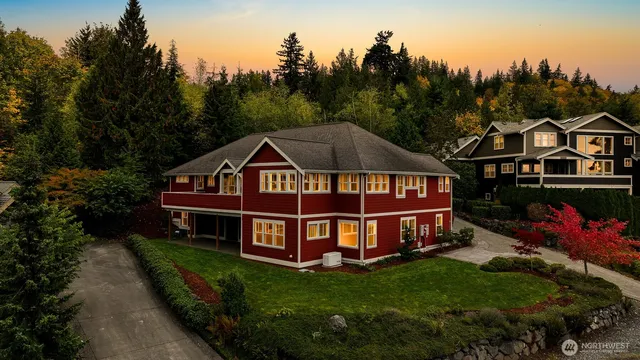 a view of a house with a big yard and large trees