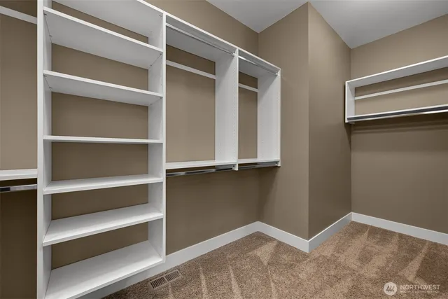 a view of walk in closet with empty racks