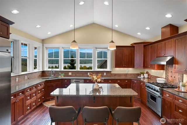 a kitchen with stainless steel appliances granite countertop a sink and a stove