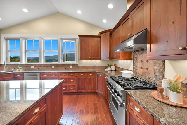 a kitchen with stainless steel appliances granite countertop a stove and a sink