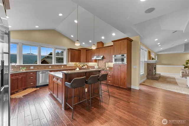 a kitchen with stainless steel appliances granite countertop a large stove a sink dishwasher and a refrigerator