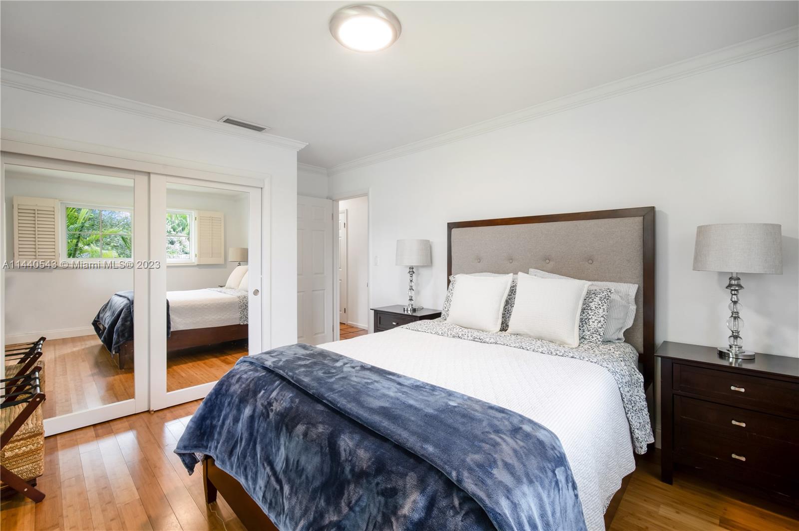 13001 Southwest 70th Avenue Pinecrest, FL 33156 - Photo 28 of 49 a bedroom with a large bed and a lamp on table