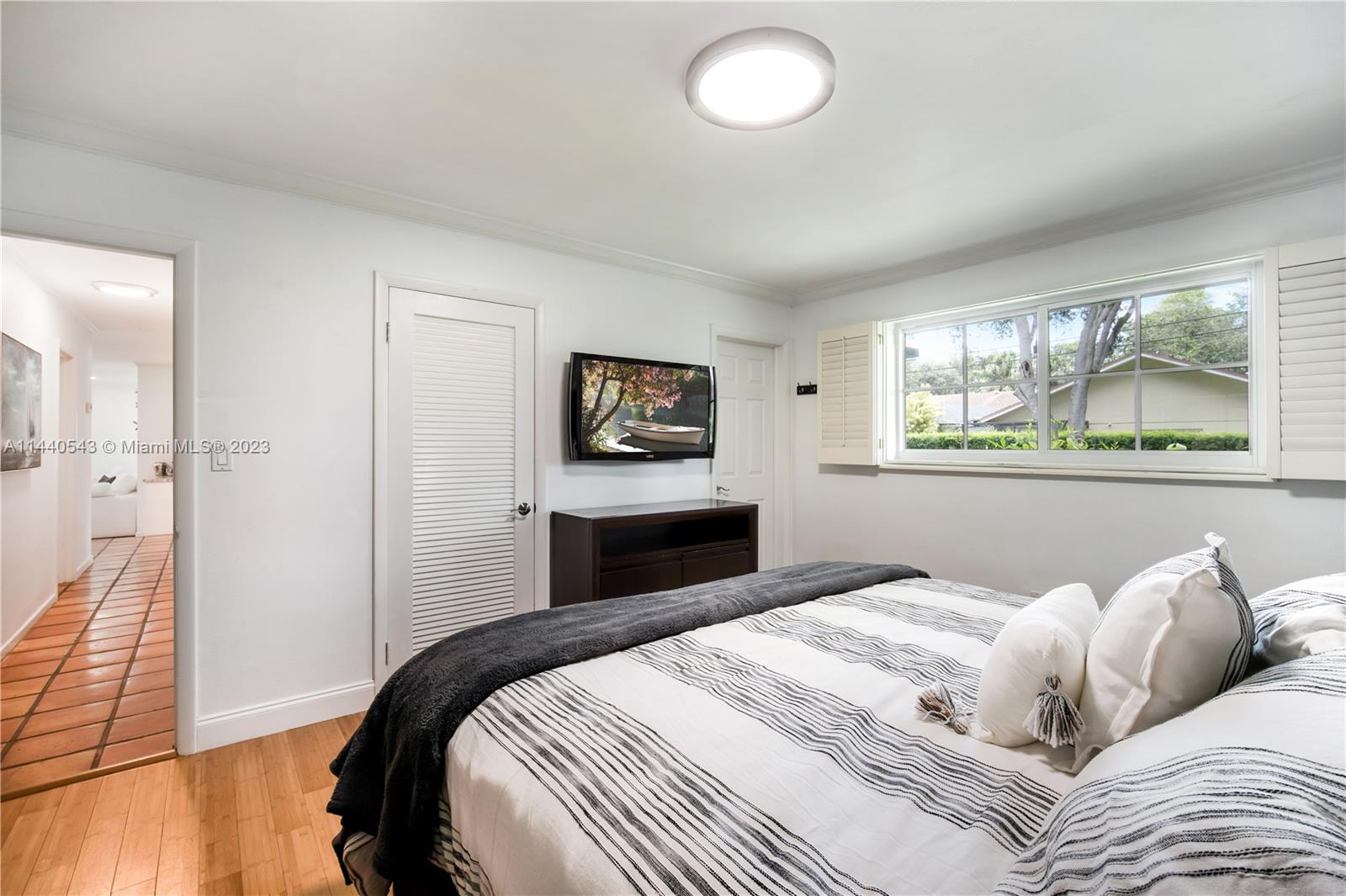 13001 Southwest 70th Avenue Pinecrest, FL 33156 - Photo 30 of 49 a bedroom with a large bed and a window