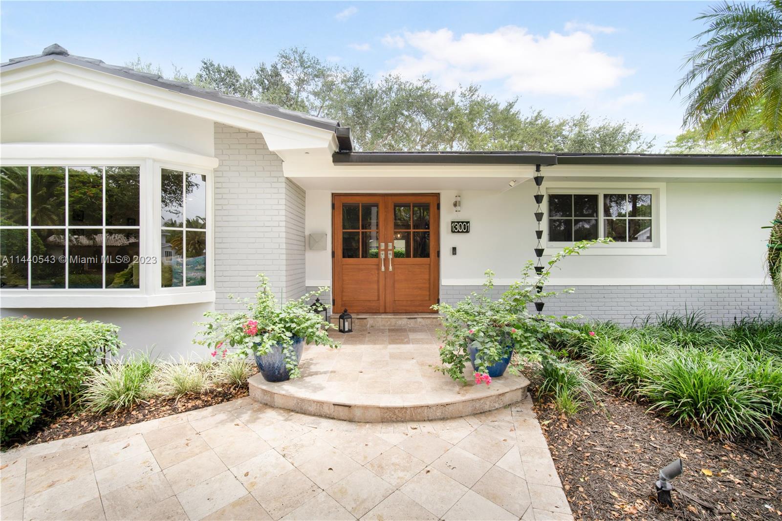 13001 Southwest 70th Avenue Pinecrest, FL 33156 - Photo 3 of 49 a front view of a house with garden