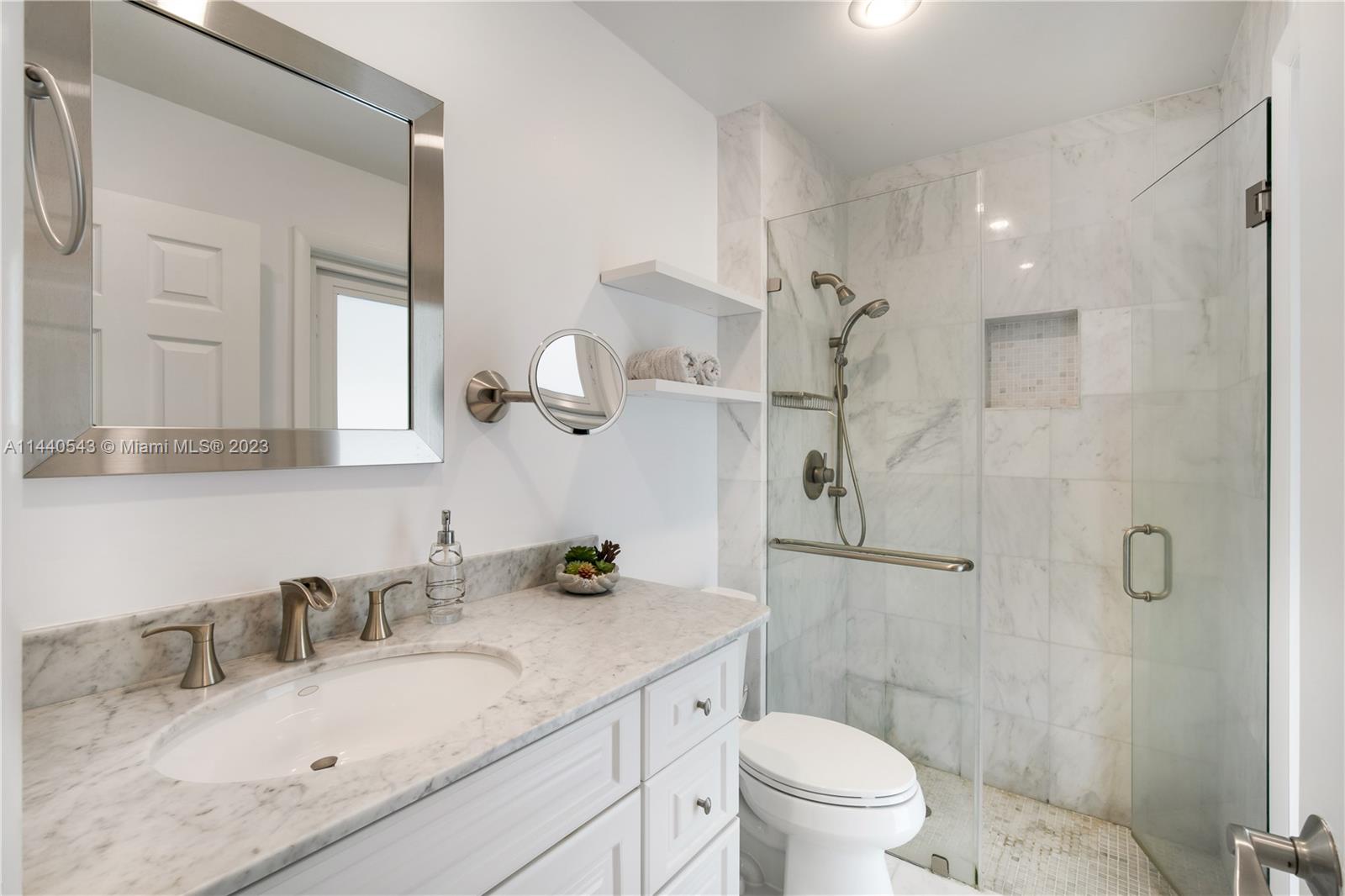 13001 Southwest 70th Avenue Pinecrest, FL 33156 - Photo 31 of 49 a bathroom with a granite countertop sink a toilet and a mirror