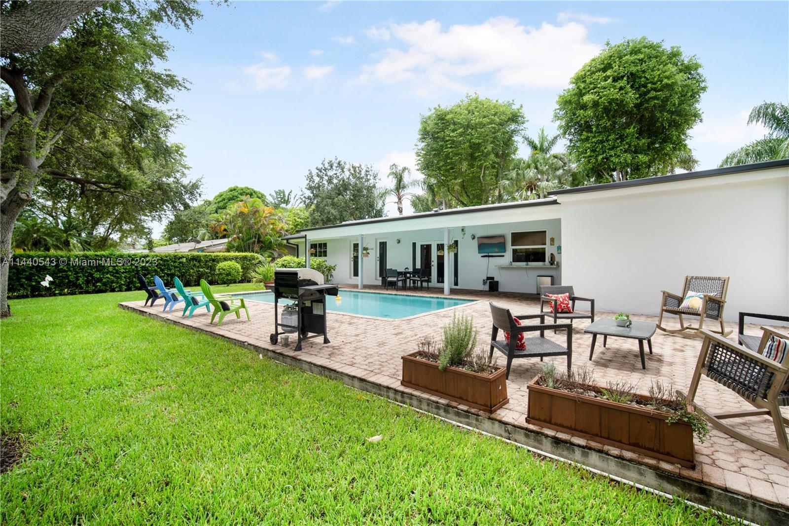 13001 Southwest 70th Avenue Pinecrest, FL 33156 - Photo 38 of 49 a view of a house with a backyard porch and sitting area