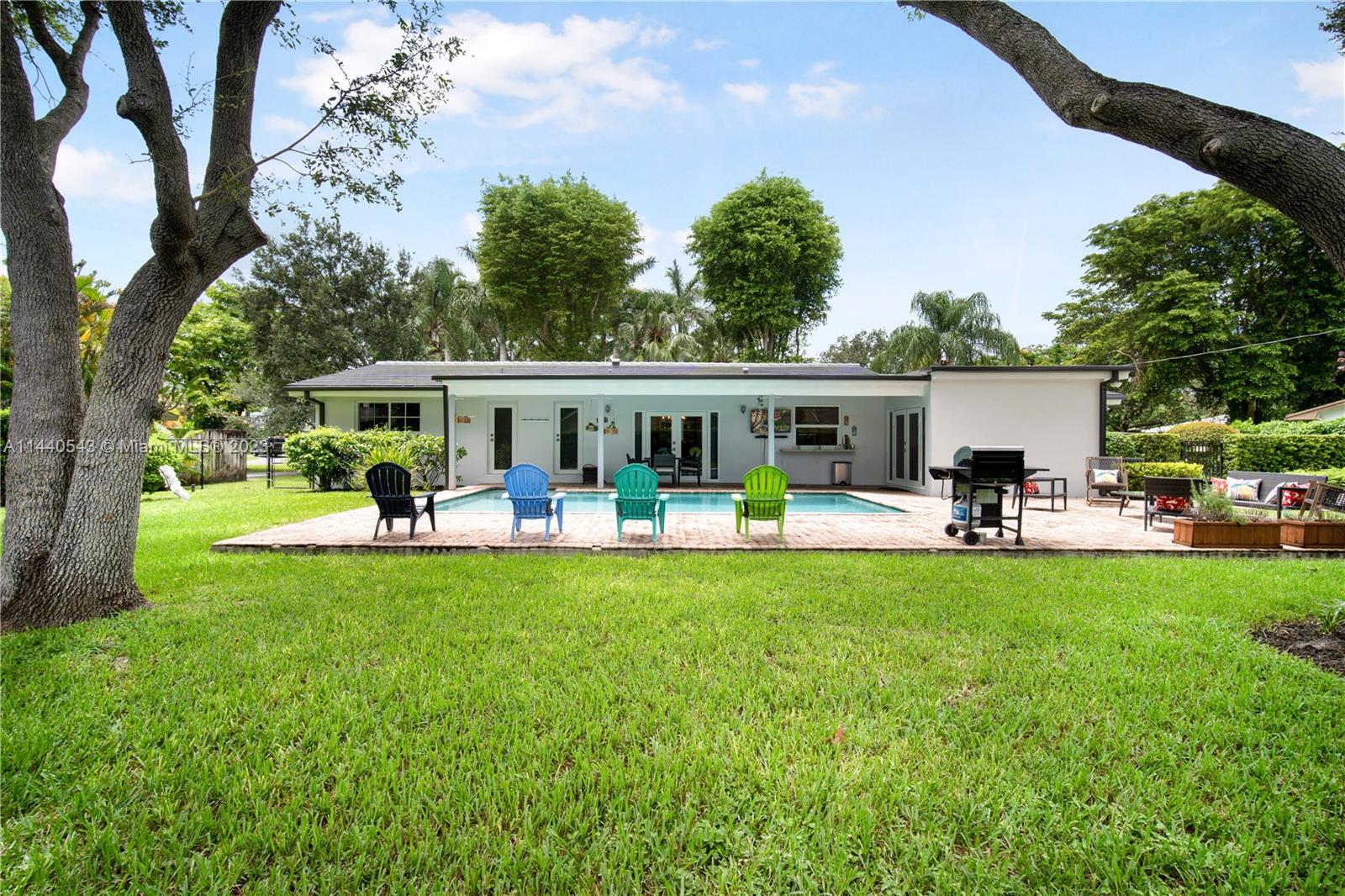 13001 Southwest 70th Avenue Pinecrest, FL 33156 - Photo 39 of 49 a front view of a house with swimming pool having outdoor seating