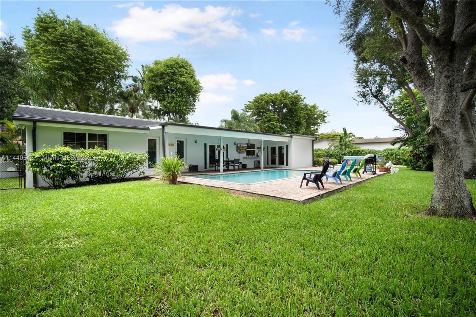 13001 Southwest 70th Avenue Pinecrest, FL 33156 - Photo 40 of 49 a view of house with a big yard and large trees