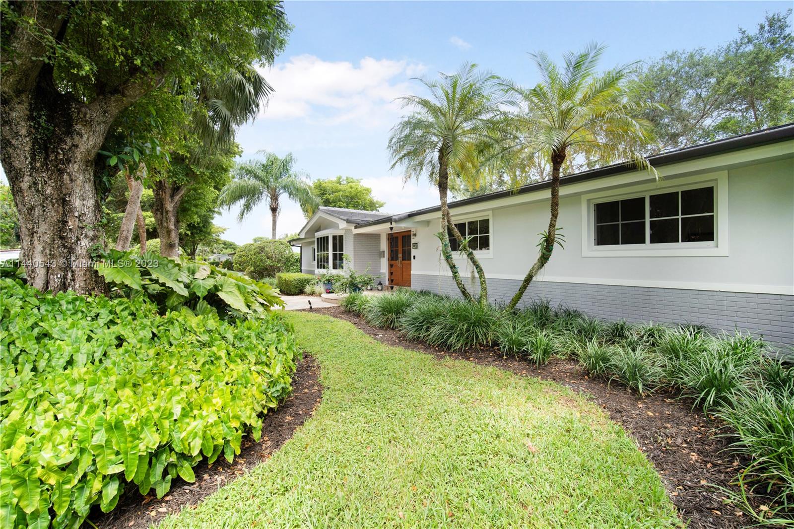 13001 Southwest 70th Avenue Pinecrest, FL 33156 - Photo 4 of 49 a front view of a house with garden