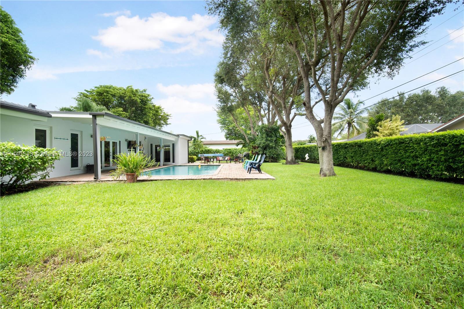 13001 Southwest 70th Avenue Pinecrest, FL 33156 - Photo 41 of 49 a front view of house with a garden and porch