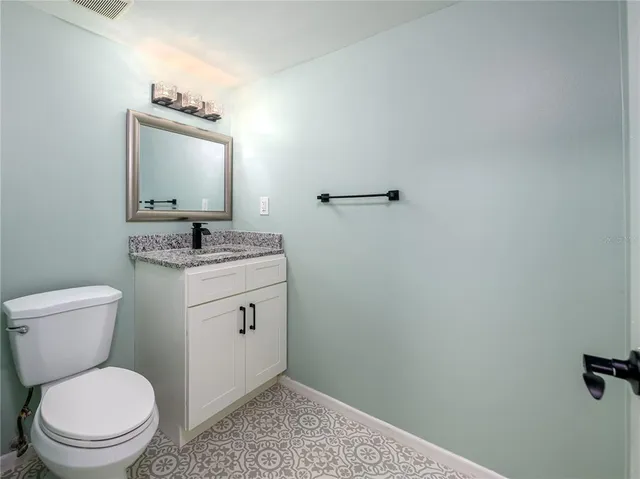 a bathroom with a toilet sink vanity and mirror