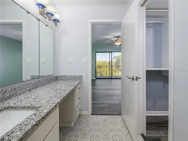 a bathroom with a granite countertop sink and a mirror