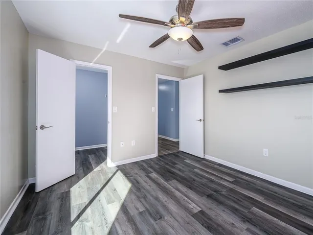 a view of empty room with wooden floor