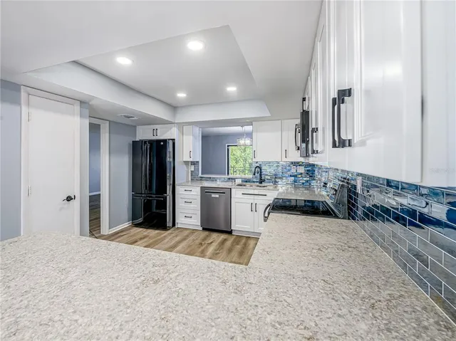 a large kitchen with kitchen island a sink stainless steel appliances and cabinets