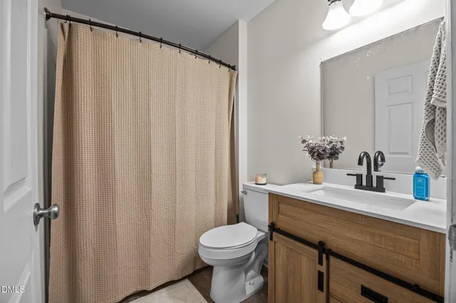 a bathroom with a sink a toilet and shower curtain
