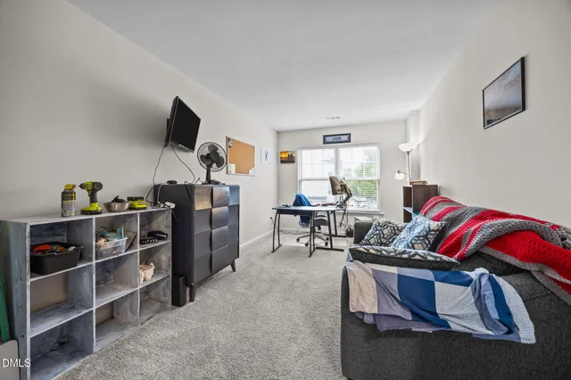 a living room with furniture a flat screen tv and gym equipment