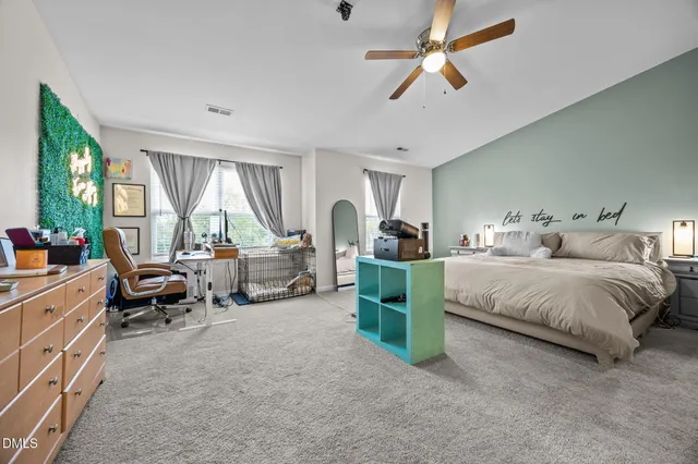 a spacious bedroom with a bed a couch and a chandelier