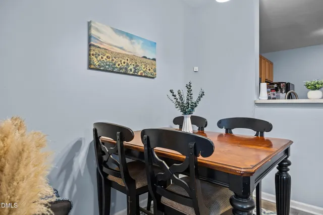 a dining room with furniture and paintings on the wall