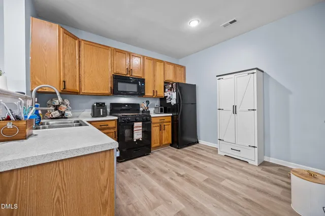 a kitchen with stainless steel appliances granite countertop a refrigerator stove top oven a sink and dishwasher