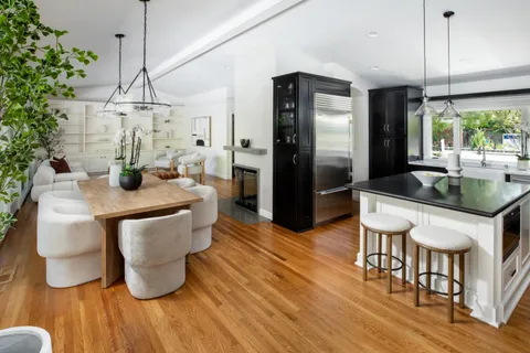an open kitchen with dining table and wooden floor