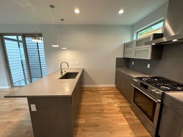a kitchen with kitchen island a sink stove and cabinets