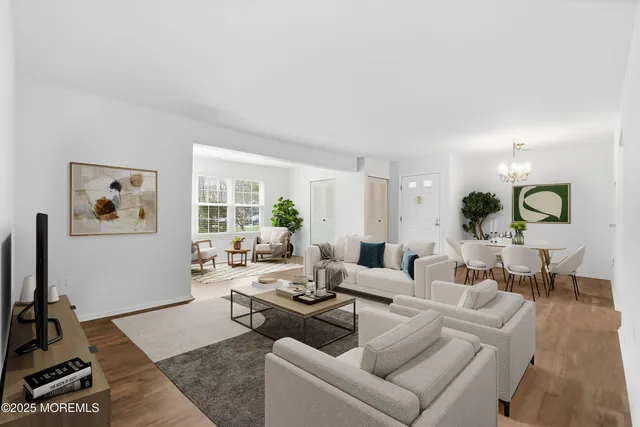 a living room with furniture and a flat screen tv with kitchen view