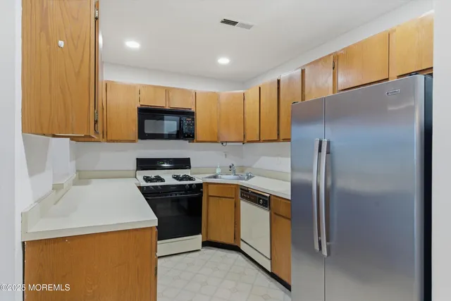 a kitchen with a sink a refrigerator and a stove top oven