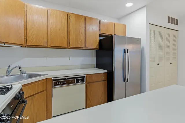 a kitchen with a refrigerator sink and cabinets