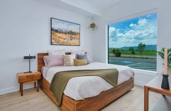 a bedroom with a bed and a painting on the wall