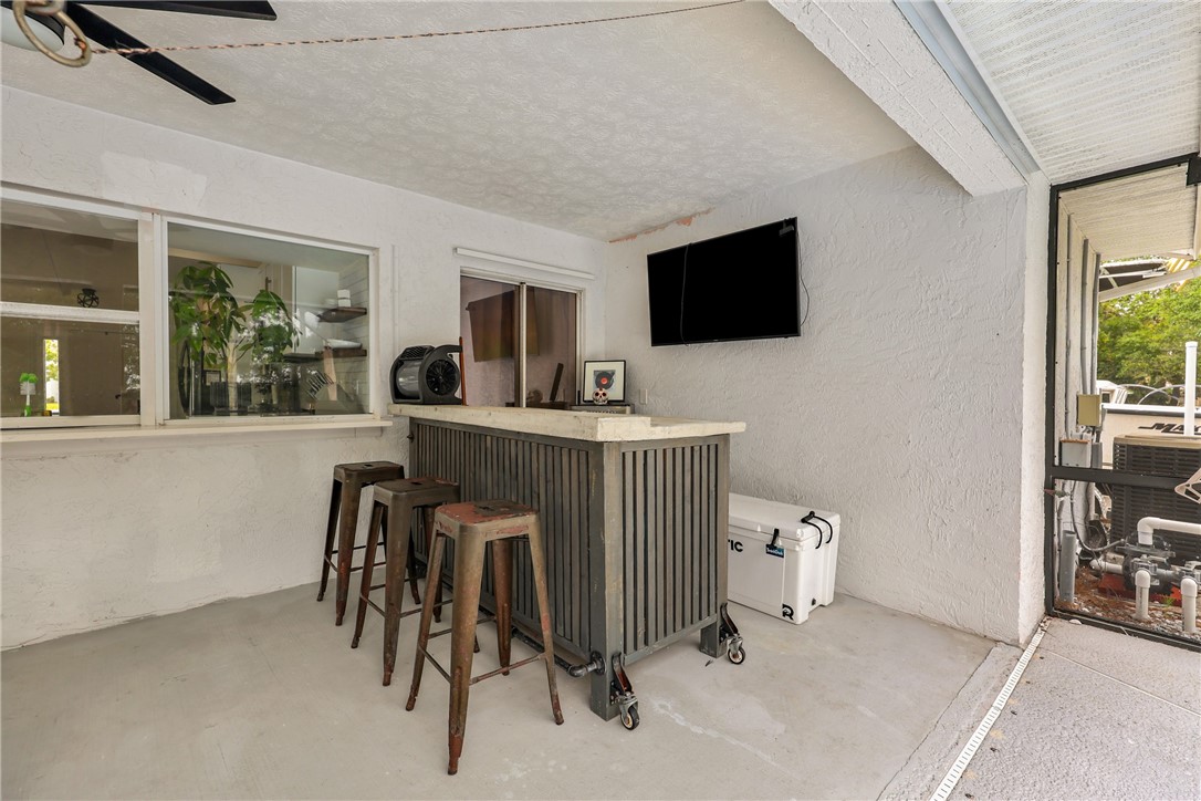 1950 Southwest Logwood Road Port St. Lucie, FL 34953 - Photo 21 of 32 a living room with furniture a flat screen tv and a large window