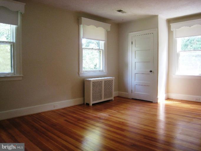 3902 Hadley Square West Baltimore, MD 21218 - Photo 12 of 30 an empty room with wooden floor and windows