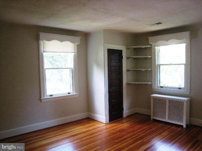 3902 Hadley Square West Baltimore, MD 21218 - Photo 15 of 30 an empty room with wooden floor closet and windows