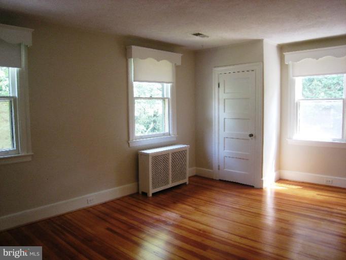 3902 Hadley Square West Baltimore, MD 21218 - Photo 21 of 30 an empty room with wooden floor and windows