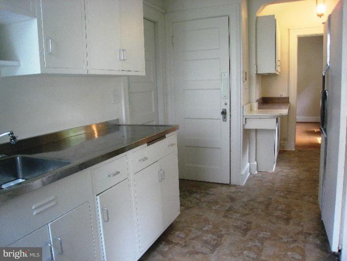 3902 Hadley Square West Baltimore, MD 21218 - Photo 26 of 30 a kitchen with granite countertop white cabinets and stainless steel appliances