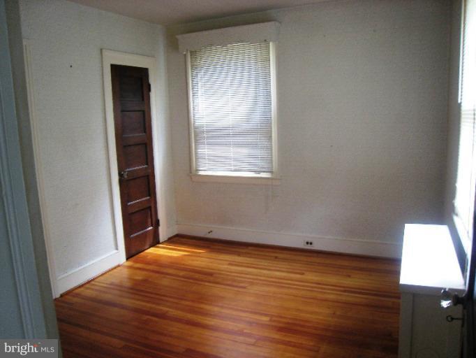 3902 Hadley Square West Baltimore, MD 21218 - Photo 27 of 30 an empty room with wooden floor and windows