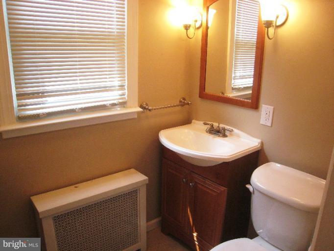 3902 Hadley Square West Baltimore, MD 21218 - Photo 9 of 30 a bathroom with a sink a toilet and a mirror