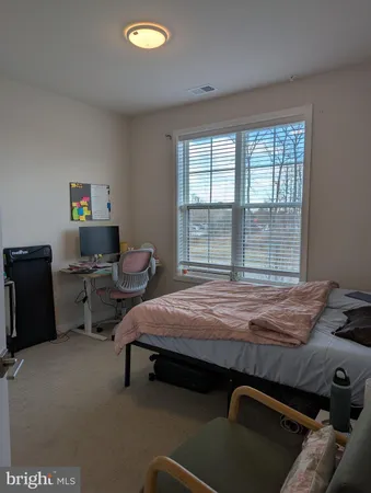 a bed sitting in a bedroom next to a window