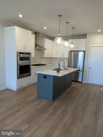 a kitchen with stainless steel appliances granite countertop a sink a stove and a refrigerator