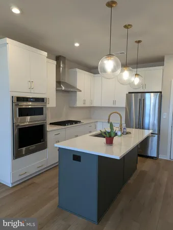 a kitchen with stainless steel appliances granite countertop a sink a stove a refrigerator and island