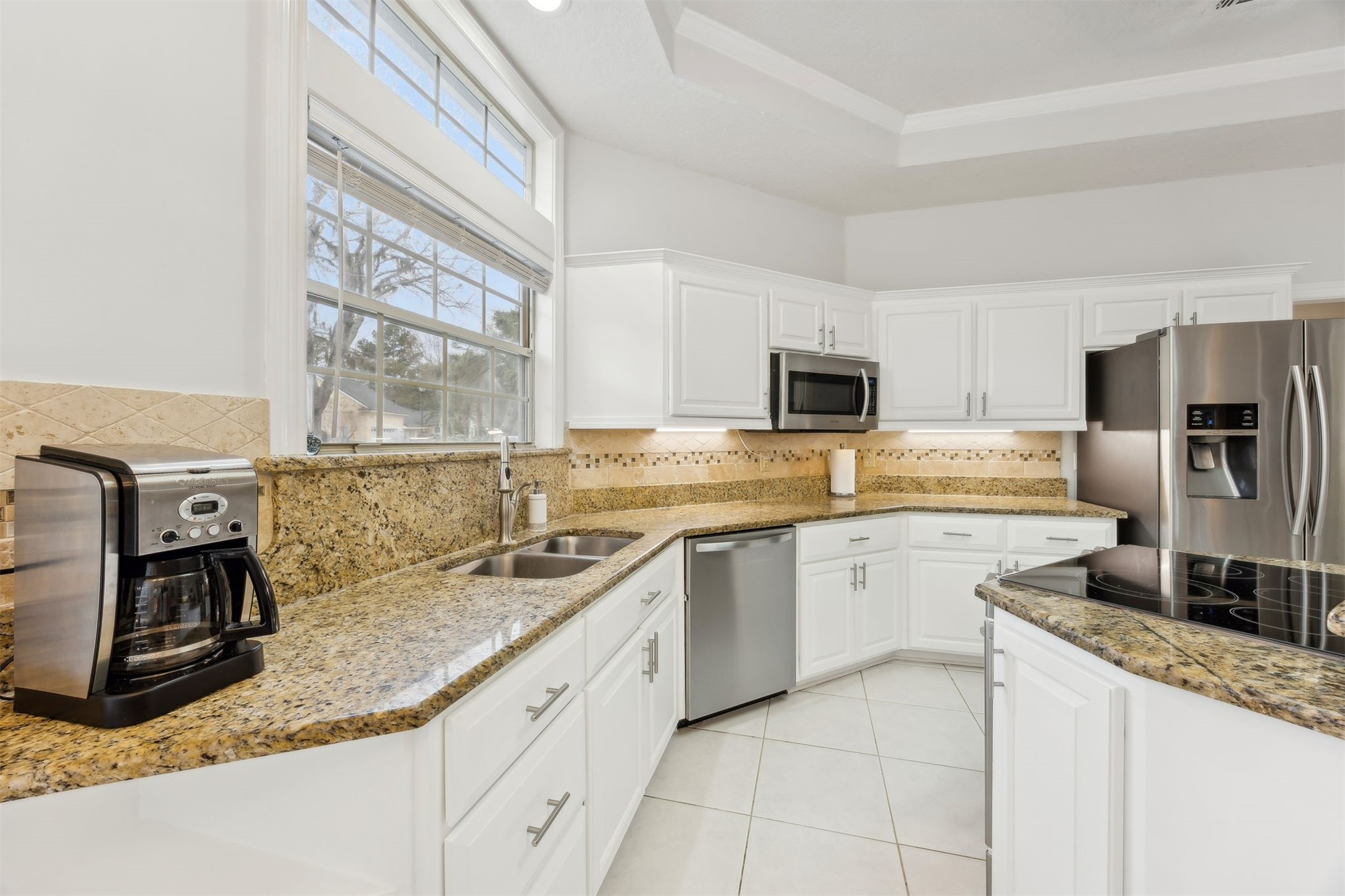 4433 Bean Street Fernandina Beach, FL 32034 - Photo 30 of 79 a kitchen with granite countertop a sink stainless steel appliances and white cabinets