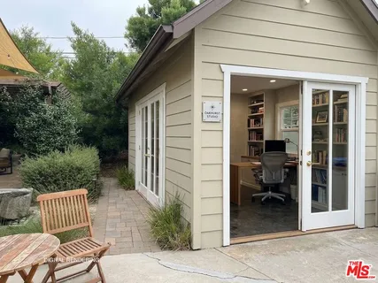 a view of backyard with outdoor seating and plants