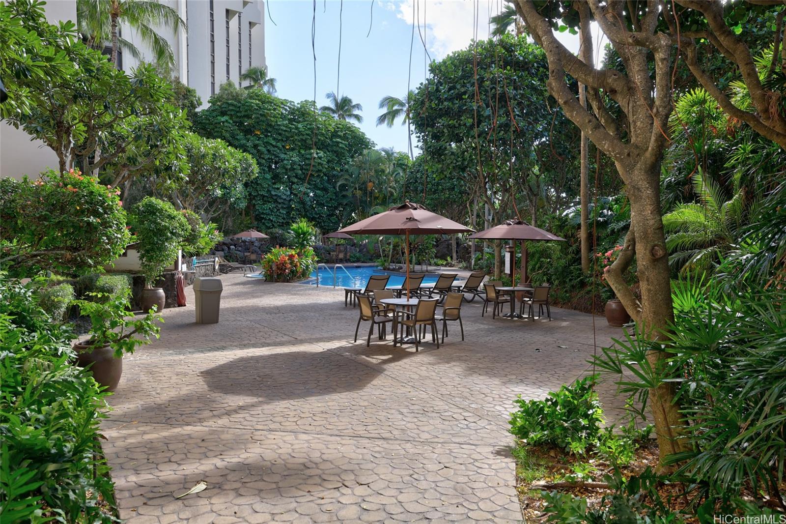 555 Hahaione Street, Unit 3E Honolulu, HI 96825 - Photo 21 of 25 a view of patio with chairs and table under an umbrella with barbeque grill and plants