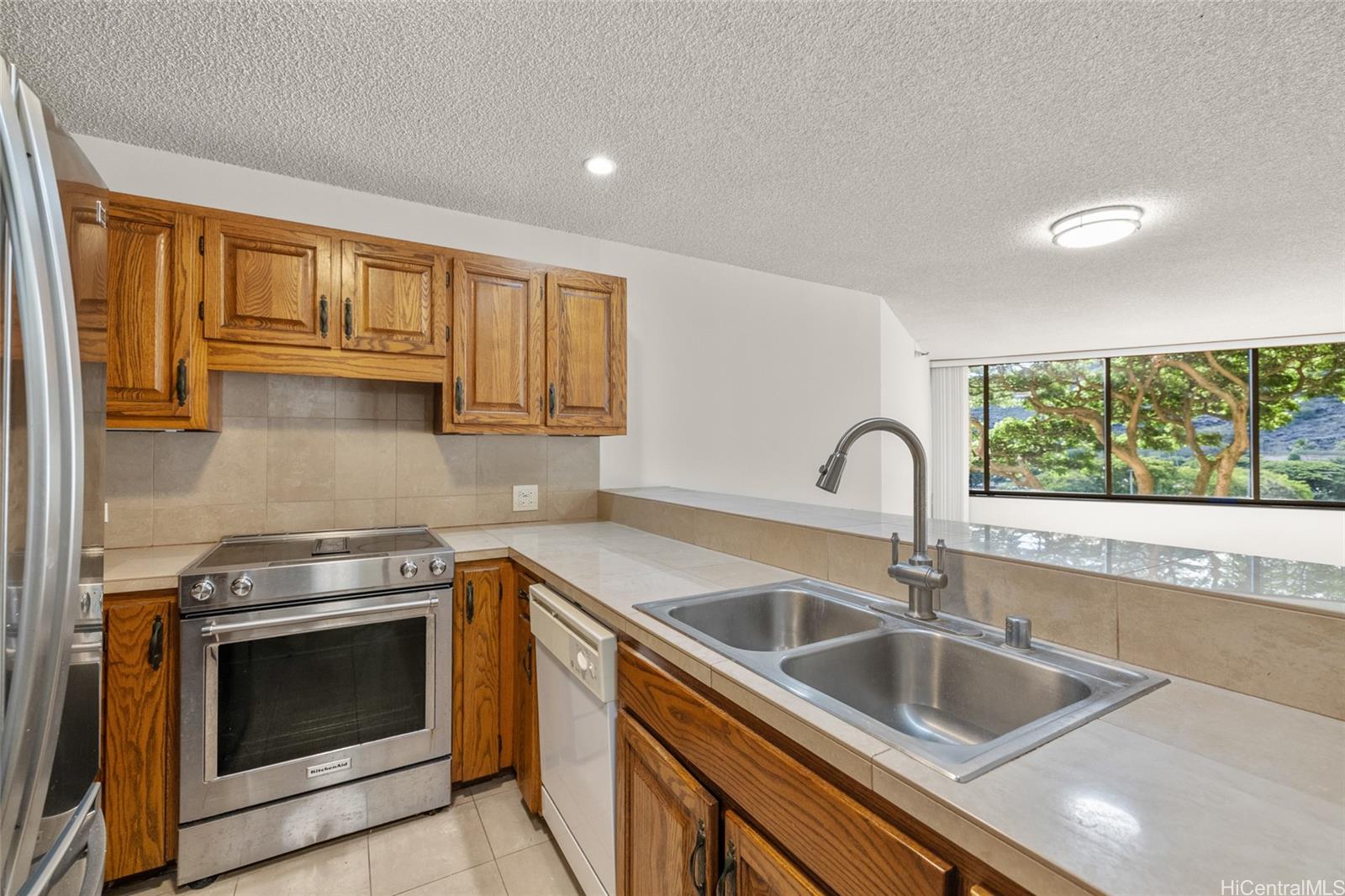 555 Hahaione Street, Unit 3E Honolulu, HI 96825 - Photo 7 of 25 a kitchen with granite countertop a sink and a stove top oven