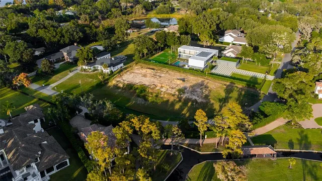 a view of swimming pool with lawn chairs and plants