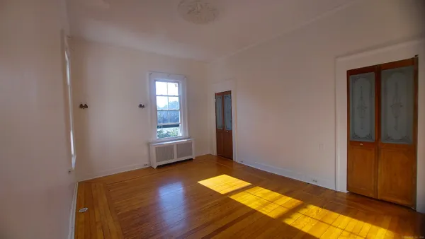 a view of room with window and wooden floor