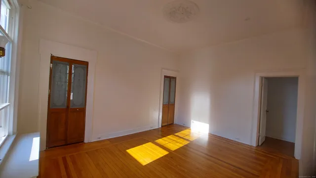 an empty room with window and wooden floor