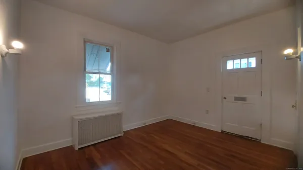 a view of an empty room with wooden floor